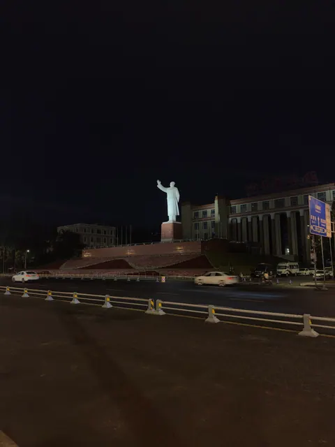 Weitläufiger Platz mit Statue bei Nacht