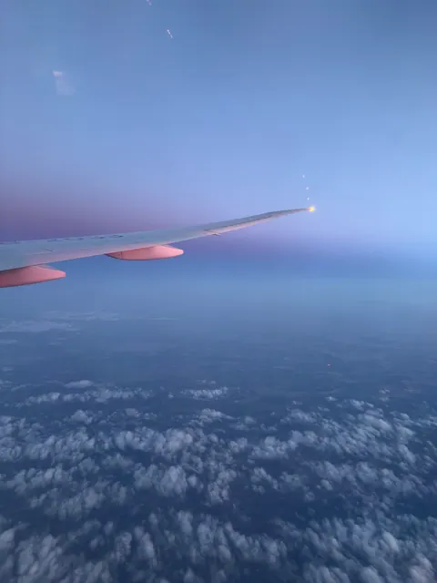 Flugzeugflügel über Wolken in der Dämmerung