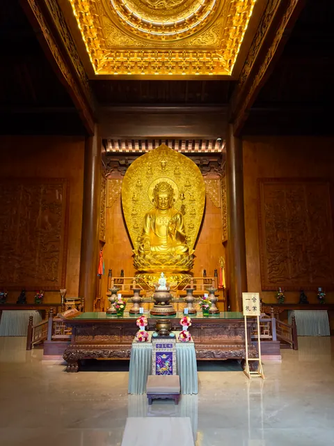 Goldene Buddha-Statue unter einer verzierten Decke
