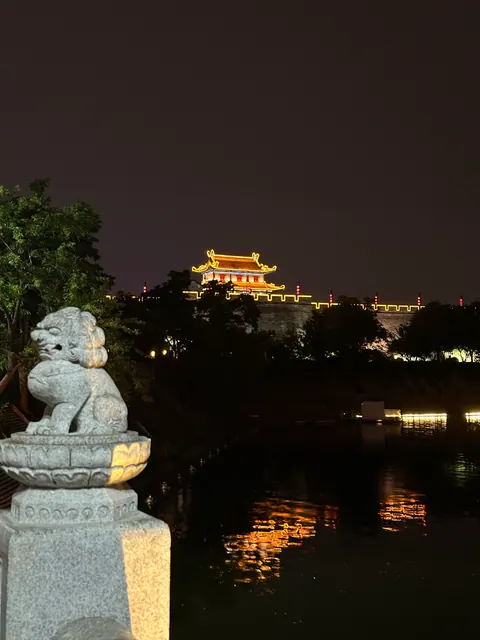 Beleuchteter Torbau am Wasser bei Nacht