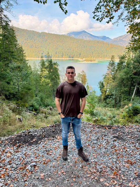 Ben auf einem Waldweg mit dem Eibsee und den Bergen im Hintergrund