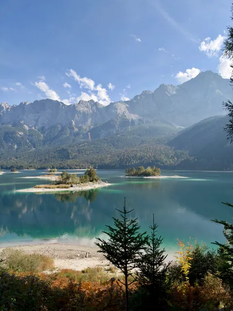 Türkisblauer Eibsee mit kleinen Inseln und dem Zugspitzmassiv im Hintergrund