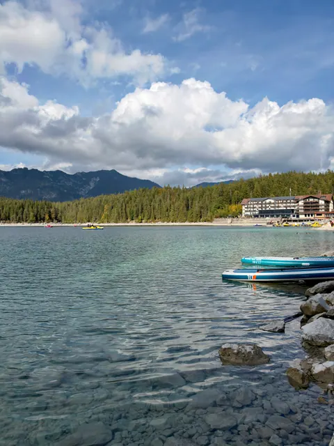 Blick vom Ufer über den Eibsee mit Bergen und Wolken im Hintergrund